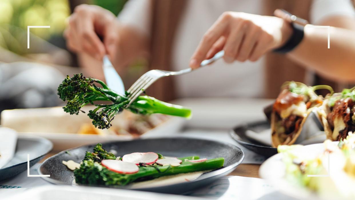  The best foods to eat in a heatwave - woman picking up sprig of broccoli 