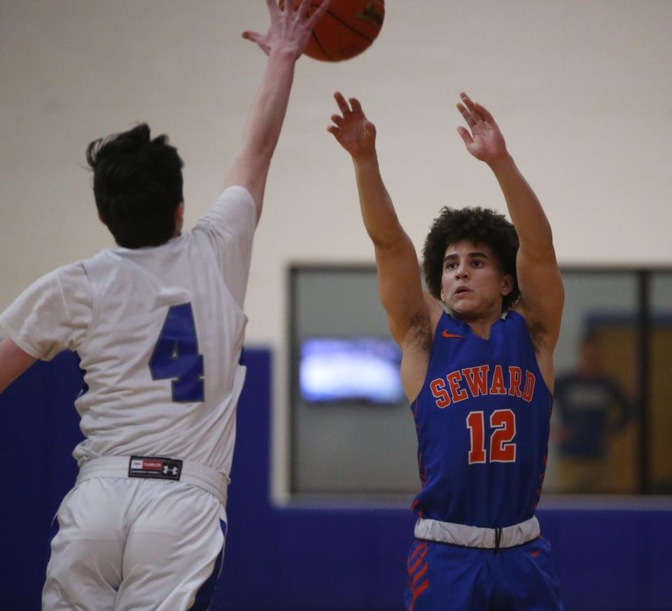 Seward's Nick Perez takes a shot over Millbrook's Cody Strickland during the Section 9 Class C championship on February 28, 2024.