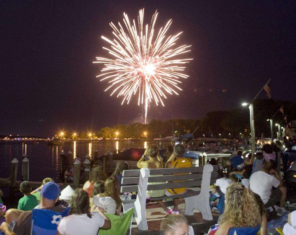 Fireworks erupt over the Toms River while viewers watch from the beach in Beachwood.