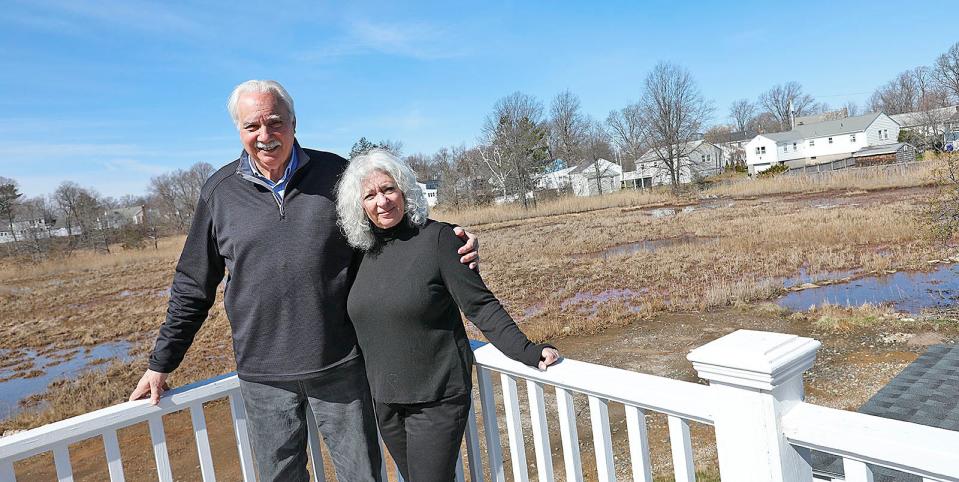 Frank and Linda Santoro on the back deck of their Beechwood Knoll home, where they enjoy views of the marshes and egrets and other birds.