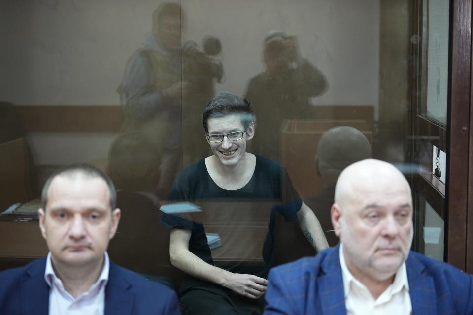 ADS THE LAWYERS NAMES - U.S. citizen Robert Woodland Romanov sits in a glass cage behind his lawyers Stanislav Kshevitskii, left, and Alexei Miroshnichenko, prior to a court session on drug-related charges in Moscow, Russia, on Thursday, April 25, 2024 The U.S. citizen arrested on drug charges in Moscow amid soaring Russia-U.S. tensions has appeared in court. Robert Woodland Romanov is facing charges of trafficking large amounts of illegal drugs as part of an organized group — a criminal offense punishable by up to 20 years in prison. (AP Photo/Alexander Zemlianichenko)