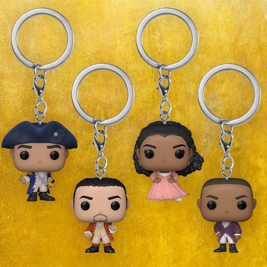 Four Hamilton Funko Pop keychains against a gold background