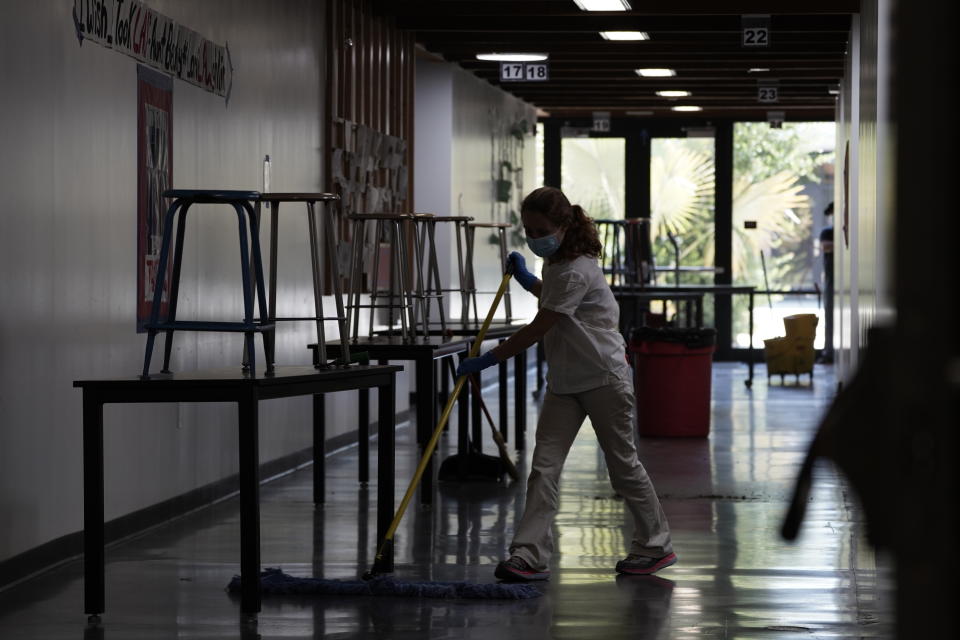 A maintenance worker mops a hallway floor at Torrey Pines High School in San Diego, California, U.S., on Friday, July 10, 2020. (Bing Guan/Bloomberg via Getty Images)