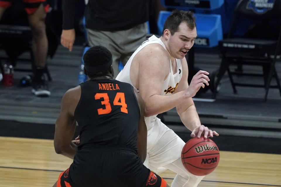 Loyola Chicago center Cameron Krutwig drives around Oregon State forward Rodrigue Andela (34) during the first half of a Sweet 16 game in the NCAA men's college basketball tournament at Bankers Life Fieldhouse, Saturday, March 27, 2021, in Indianapolis. (AP Photo/Jeff Roberson)