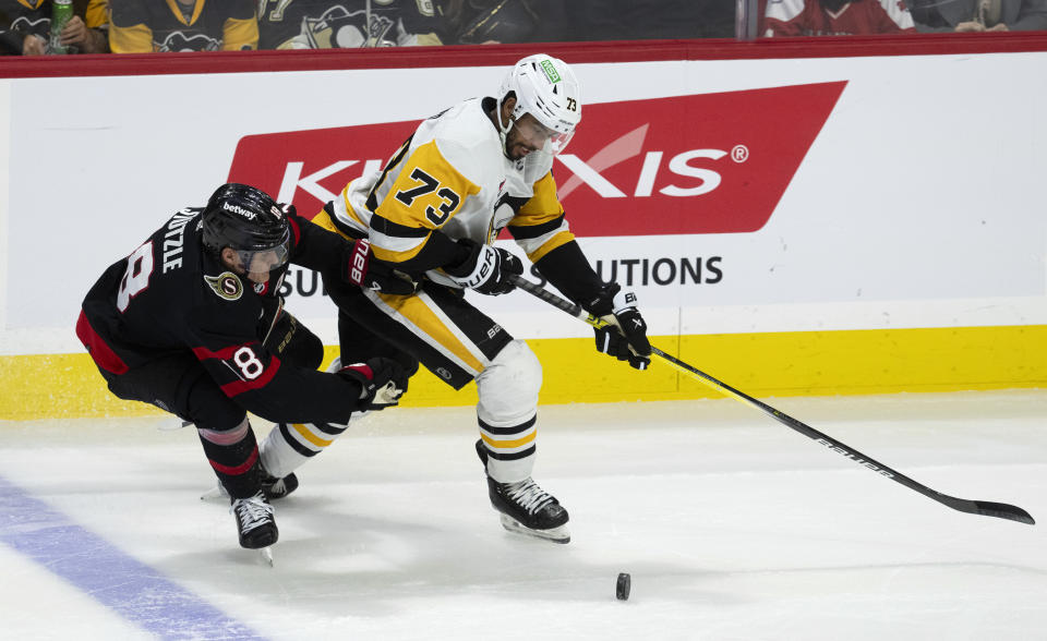 Pittsburgh Penguins defenseman Pierre-Olivier Joseph, right, collides with Ottawa Senators center Tim Stutzle and takes control of the puck during the second period of an NHL hockey game, Tuesday, March 12, 2024, Ottawa, Ontario. (Adrian Wyld/The Canadian Press via AP)