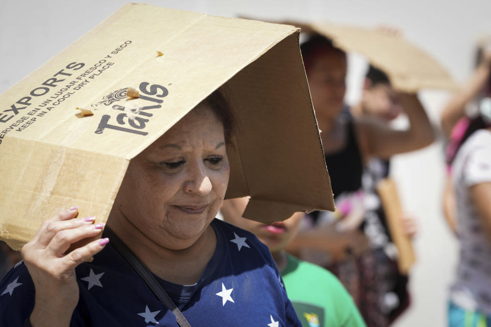 Margaret Cantu waits in the heat for food and water from volunteers Saturday, May 18, 2024, at Sam Houston Math, Science and Technology Center in Houston. "I'm trying to forget the storm, it really scares me," she said. Cantu, 68, lives with her 70-year-old husband. She said they don't have power. (Jon Shapley/Houston Chronicle via AP)/Houston Chronicle via AP)