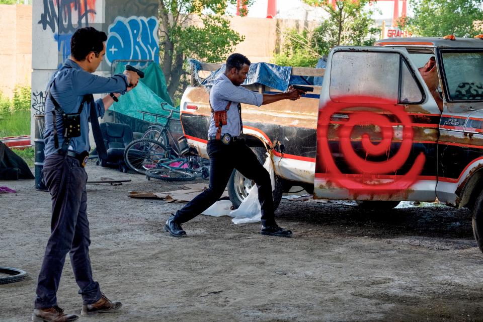 Max Minghella (left) and Chris Rock star as detectives investigating a series of murders marked by an eerie symbol in the horror film "Spiral," the latest in the long-running "Saw" franchise.