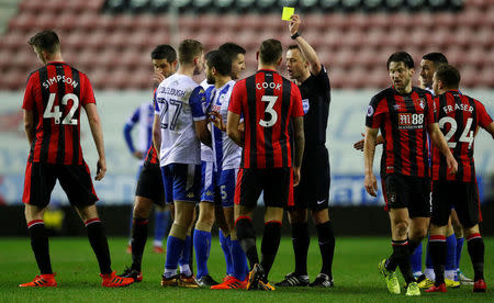 Soccer Football - FA Cup Third Round Replay - Wigan Athletic vs AFC Bournemouth - DW Stadium, Wigan, Britain - January 17, 2018 Referee Stuart Attwell shows a yellow card as Wigan Athletic’s Ryan Colcough looks on REUTERS/Phil Noble