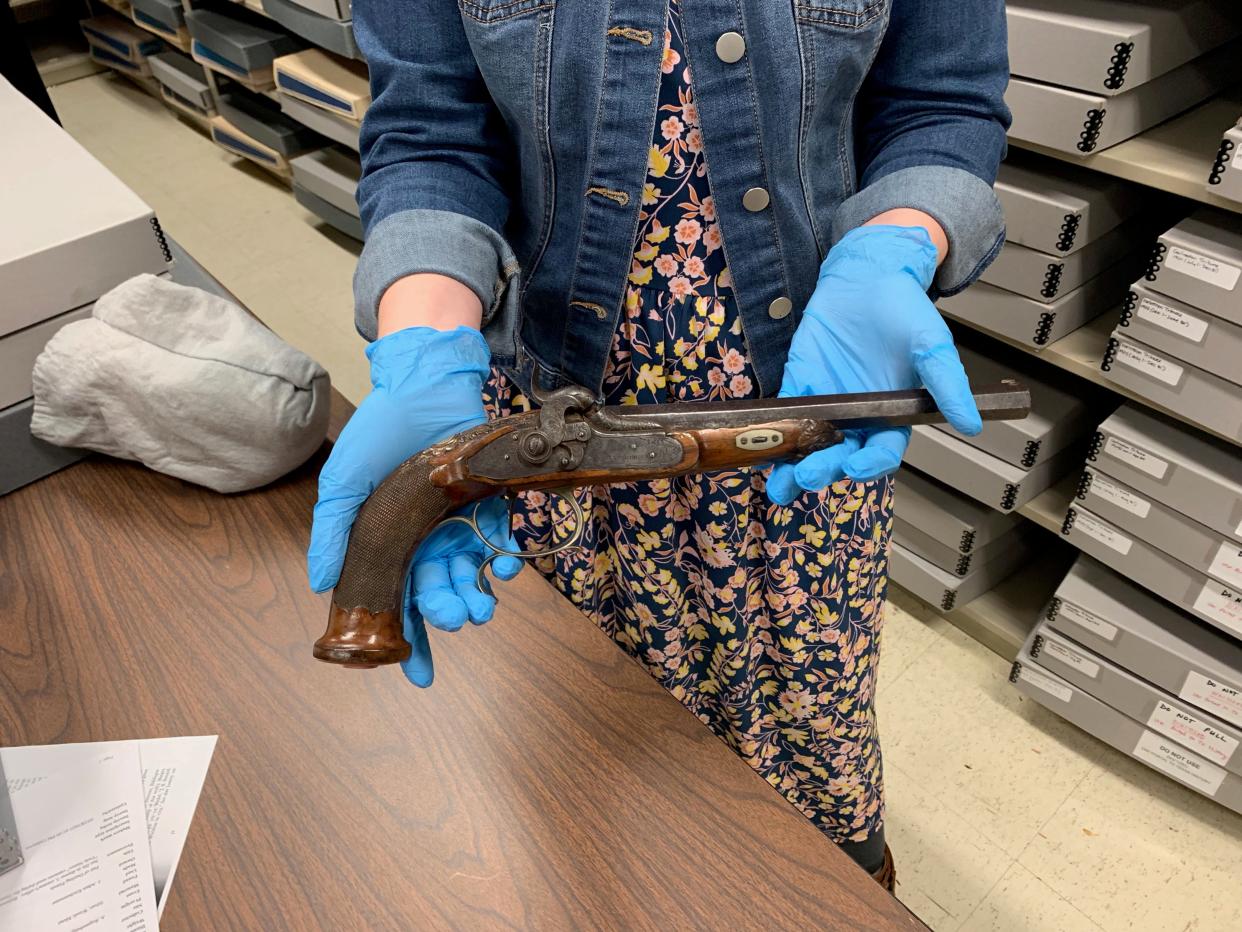 Lauren Martino Henry, special collections manager at the Rosenberg Library in Galveston, holds one of a pair of Sam Houston's ceremonial dueling pistols. Although challenged multiple times, Houston never discharged them.