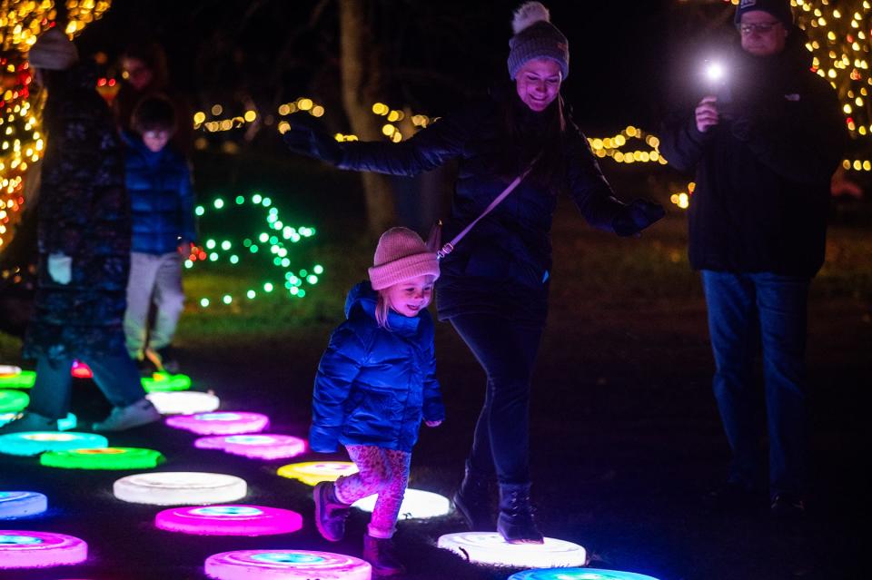 Ainley Griffin, 3, of South Berry runs on an interactive light element during the Festival of Lights at Harvest Moon Farm and Orchard in North Salem, NY on Friday, November 25, 2023.