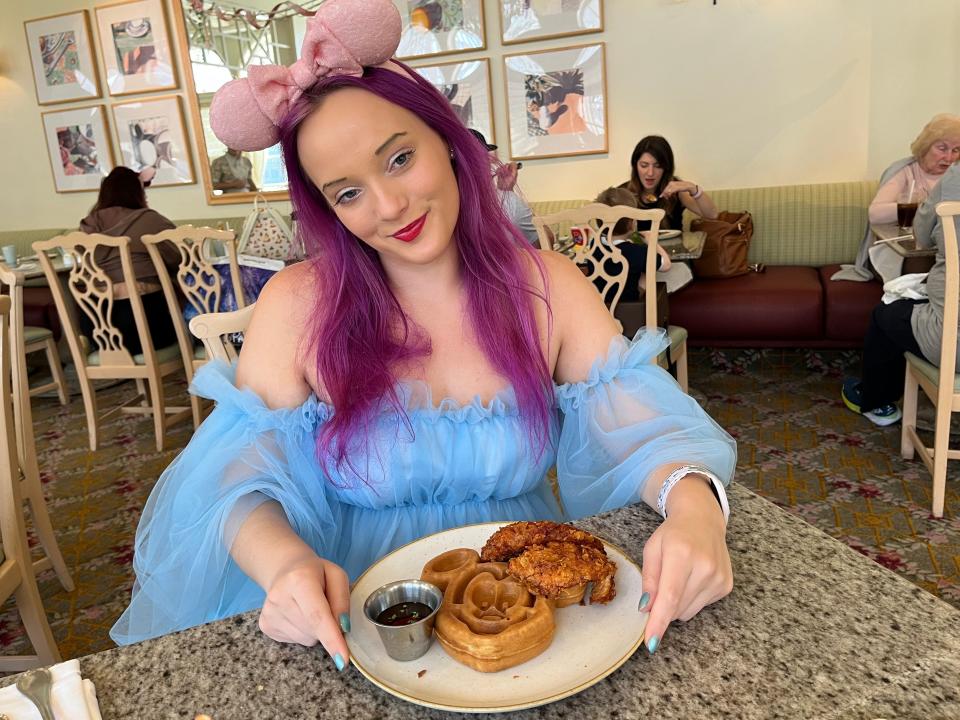 jenna posing wiht a plate of chicken and waffles at grand floridian cafe
