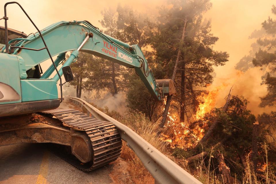A digger helps to extinguish a forest fire near Datca (AFP/Getty)