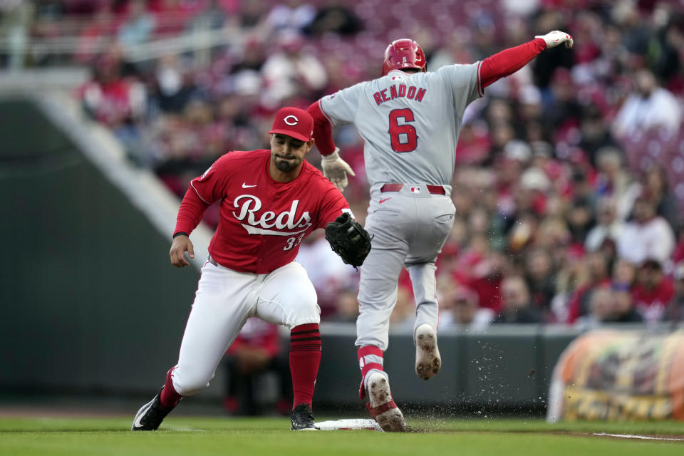 Cincinnati Reds first base Christian Encarnacion-Strand (33) reaches for the throw as Los Angeles Angels Anthony Rendon (6) is safe at first in the first inning of a baseball game on Saturday, April 20, 2024, in Cincinnati. Rendon left the game after the play due to an injured ankle. (AP Photo/Carolyn Kaster)