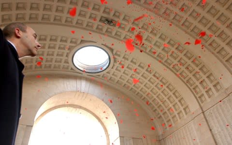 Red poppies fall from the ceiling of the Menin Gate in Ypres, Belgium - Credit: AP Photo/Virginia Mayo