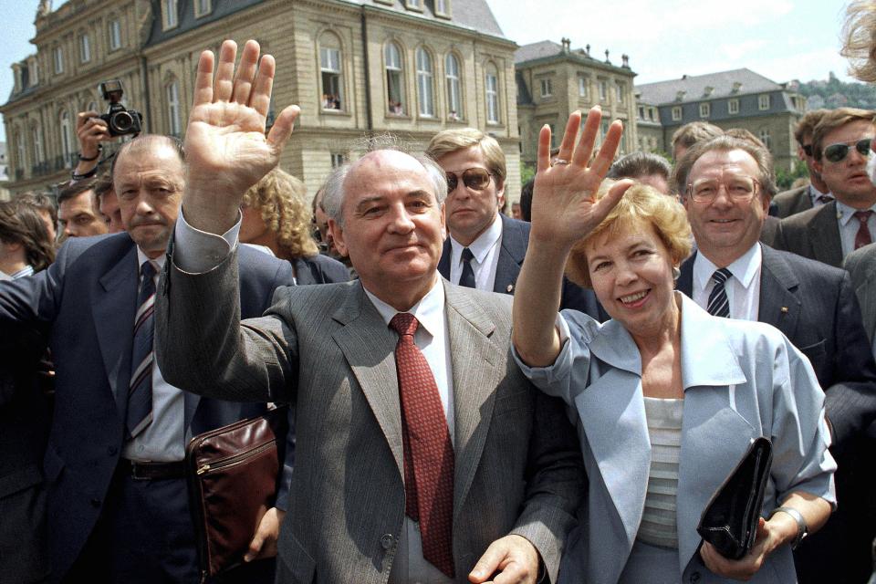 FILE - Soviet President Mikhail S. Gorbachev (l) and his wife Raisa wave to well wishers when strolling through market place in downtown Stuttgart, Wednesday, June 14, 1989. In background is the New Castle where Gorbachev had talks with representatives of West German state Baden-Wurttemberg. When Mikhail Gorbachev is buried Saturday at Moscow's Novodevichy Cemetery, he will once again be next to his wife, Raisa, with whom he shared the world stage in a visibly close and loving marriage that was unprecedented for a Soviet leader. Gorbachev's very public devotion to his family broke the stuffy mold of previous Soviet leaders, just as his openness to political reform did. (AP Photo/Arne Dedert, File)