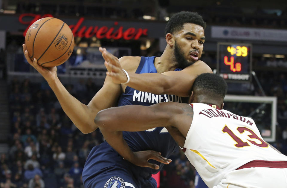 Minnesota Timberwolves' Karl-Anthony Towns, left, runs into Cleveland Cavaliers' Tristan Thompson as he drives in the first half of an NBA basketball game Friday, Oct. 19, 2018, in Minneapolis. (AP Photo/Jim Mone)