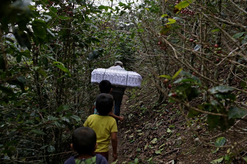 Marvin Roque carries the coffin of his late niece Yesmin Anayeli towards a hilltop for her burial in La Palmilla