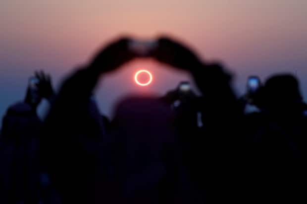 People take photos as they watch the annular solar eclipse on Jabal Arba (Four Mountains) in Hofuf, Saudi Arabia on Dec. 26, 2019. (Hamad I Mohammed/Reuters - image credit)