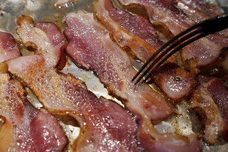 Bacon is fried up in a pan in a kitchen in this photo illustration in Golden, Colorado, October 26, 2015. REUTERS/Rick Wilking