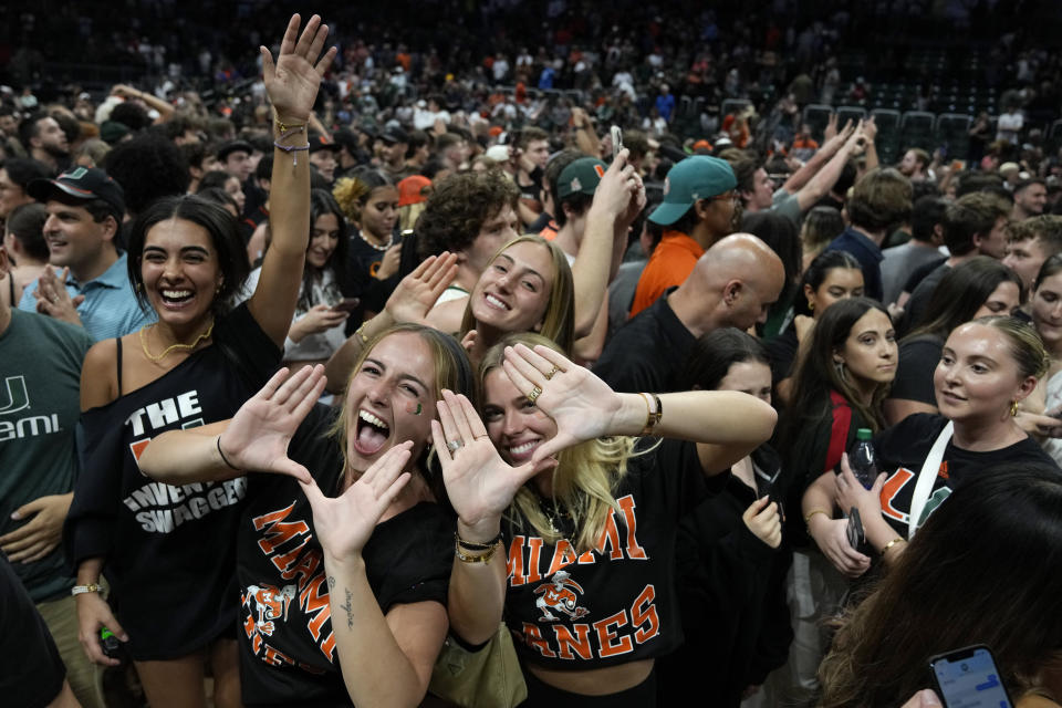 Miami fans celebrate on the court after Miami defeated Pittsburgh in an NCAA college basketball game to win a share of the Atlantic Coast Conference regular season championship with Virginia, Saturday, March 4, 2023, in Coral Gables, Fla. (AP Photo/Rebecca Blackwell)