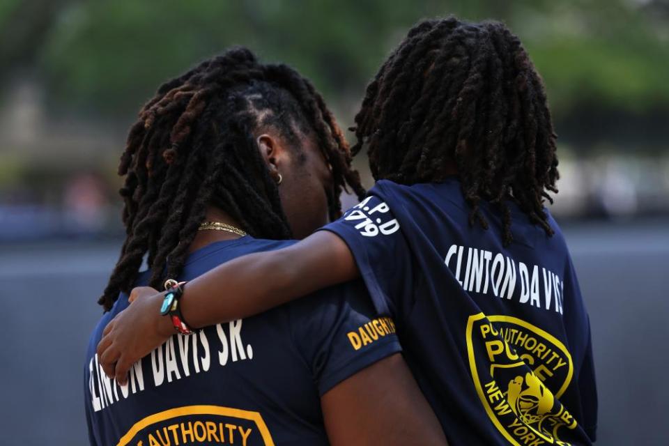 Priscella Davis, daughter of the fallen Port Authority police officer Clinton Davis Sr, holds her son Jaxson as they view his name during the ceremony.