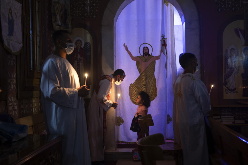 Coptic Orthodox deacon Micheal Assad listens to a girl during Easter mass, at Holy Cross Church in Cairo, Egypt, Saturday, May 1, 2021. Orthodox Christians around the world celebrate Easter on Sunday, May 2. (AP Photo/Nariman El-Mofty)