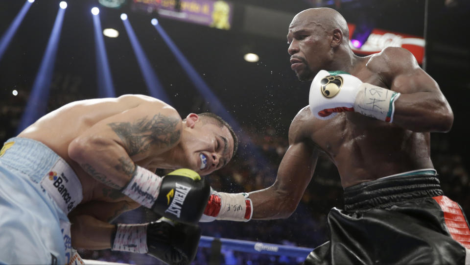 Floyd Mayweather Jr., right, connects with a right to the head of Marcos Maidana, from Argentina, in their WBC-WBA welterweight title boxing fight Saturday, May 3, 2014, in Las Vegas. (AP Photo/Isaac Brekken)