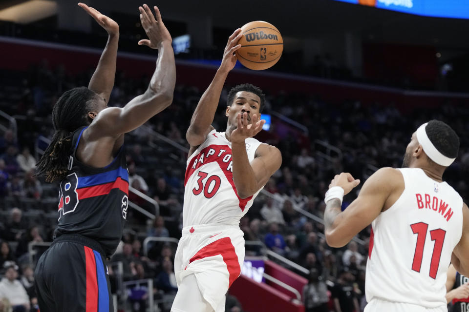 Toronto Raptors guard Ochai Agbaji (30) passes as Detroit Pistons center Isaiah Stewart (28) defends during the first half of an NBA basketball game, Wednesday, March 13, 2024, in Detroit. (AP Photo/Carlos Osorio)