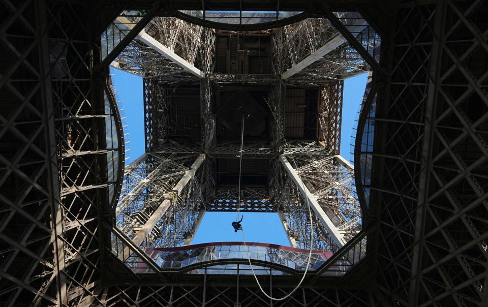 Ms Garnier, an Olympic ambassador, pulling herself up by rope inside the Eiffel Tower in Paris