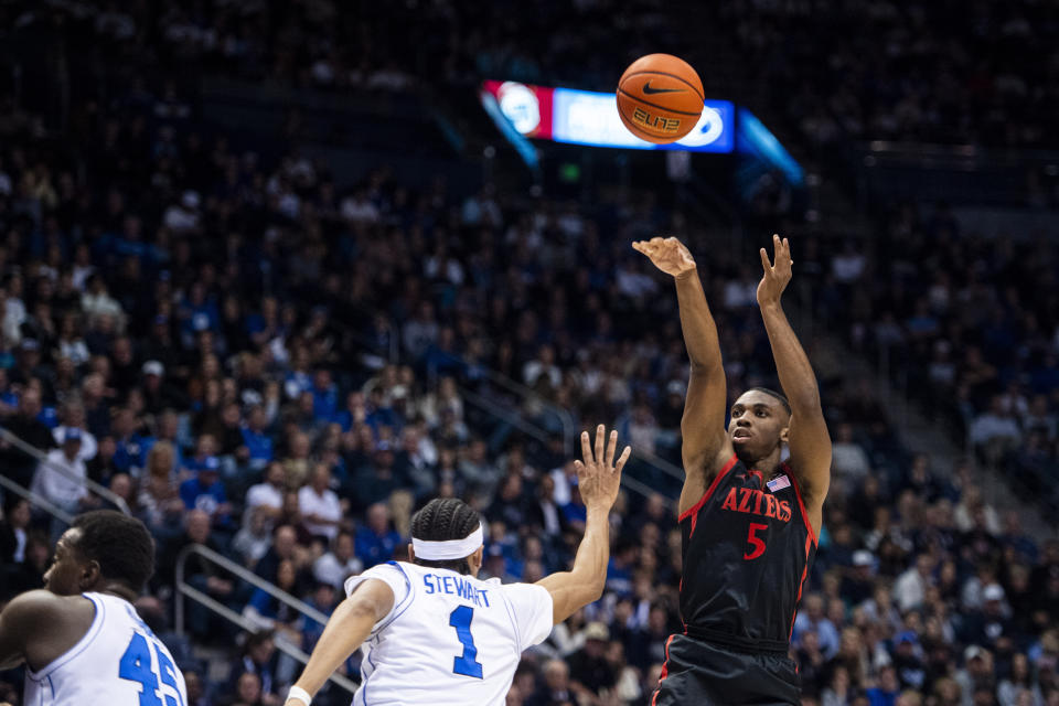 San Diego State guard Lamont Butler (5) shoots over BYU guard Trey Stewart (1) during the first half of an NCAA college basketball game Friday, Nov. 10, 2023, in Provo, Utah. (AP Photo/Isaac Hale)