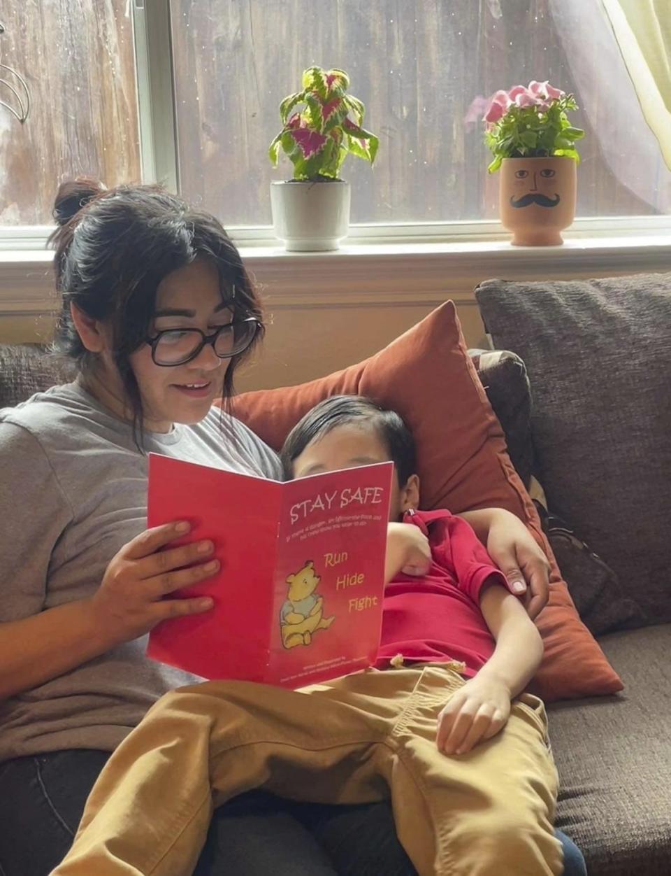 Cindy Campos reads the book "Stay Safe" to her son in Dallas. Cindy Campos' 5-year-old son was so excited about the book that had been sent home with him from school featuring Winnie-the-Pooh that he wanted to read it immediately. But her heart sank as she flipped through the pages advising children what to do if “danger is near,” including locking doors, turning off the lights and quietly hiding till police arrive. (Cindy Campos via AP)