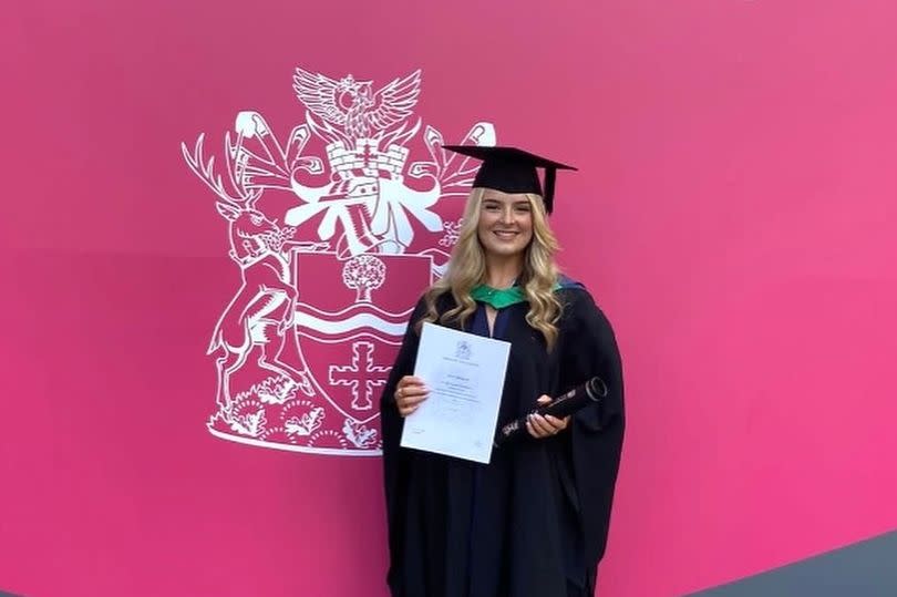 Holly Whitehall stood in her gown and hat after graduating university