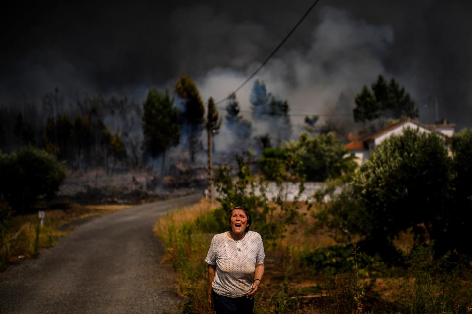 A villager shouts for help as a wildfire approaches a house at Casas da Ribeira village in Macao, central Portugal on July 21, 2019. (Photo: Patricia De Melo Moreira/AFP/Getty Images)