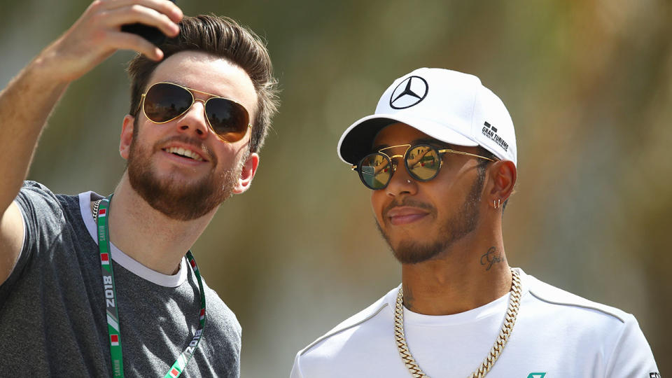 A fan at the Bahrain Grand Prix poses for a selfie with Mercedes driver Lewis Hamilton.