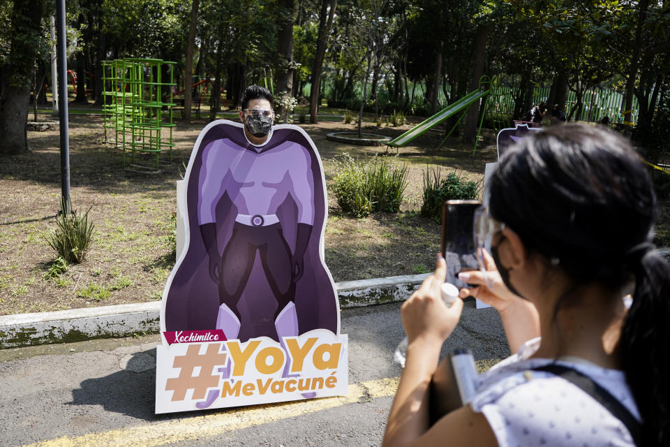 A man poses for a souvenir photo with his face positioned on a superhero cutout with a hashtag that reads in Spanish: "I've been vaccinated", during a vaccination campaign against COVID-19 for people between the ages of 18 to 29, in Mexico City, Thursday, Aug. 19, 2021. (AP Photo/Eduardo Verdugo)