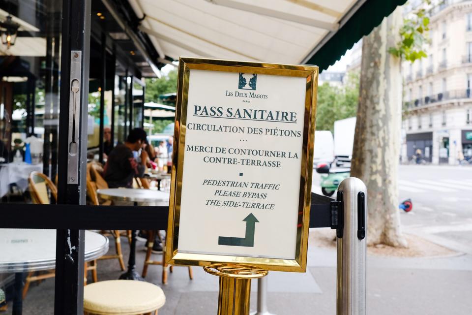 A sign asking for your health pass at the entrance to a cafe in Paris, France