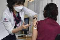 A medical worker receives a dose of the Pfizer BioNTech COVID-19 vaccine at the National Medical Center vaccination center in Seoul Saturday, Feb. 27, 2021. South Korea began vaccinating tens of thousands of workers at front-line hospitals in the second day of its mass immunization program. (Song Kyung-Seok/Pool Photo via AP)