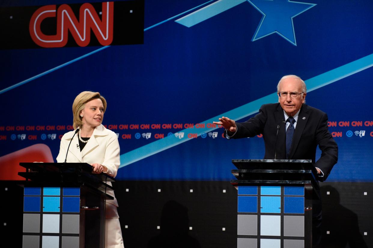 Kate McKinnon (Left) stands at a podium as Elizabeth Warren and Larry David (Right) stands at a podium as Bernie Sanders 