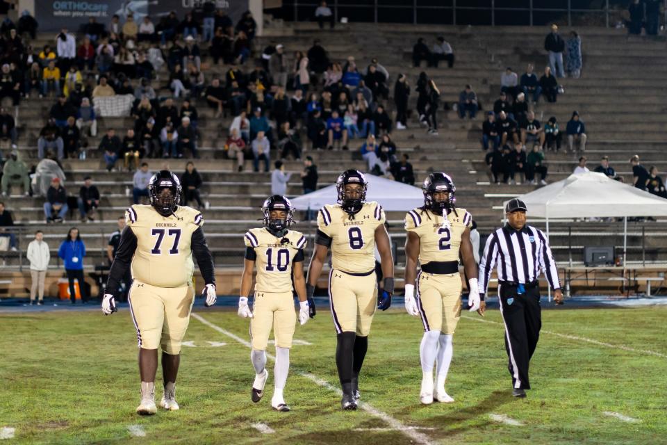 Buchholz Bobcats guard Perris Sylvester (77), Buchholz Bobcats running back Quinton Cutler (10), Buchholz Bobcats defensive end Kendall Jackson (8) and Buchholz Bobcats middle linebacker Myles Graham (2) walk to midfield before the game against the Bartram Trail Bears in the Regional Finals of the 2023 FHSAA Football State Championships at Citizens Field in Gainesville, FL on Friday, November 24, 2023. [Matt Pendleton/Gainesville Sun]