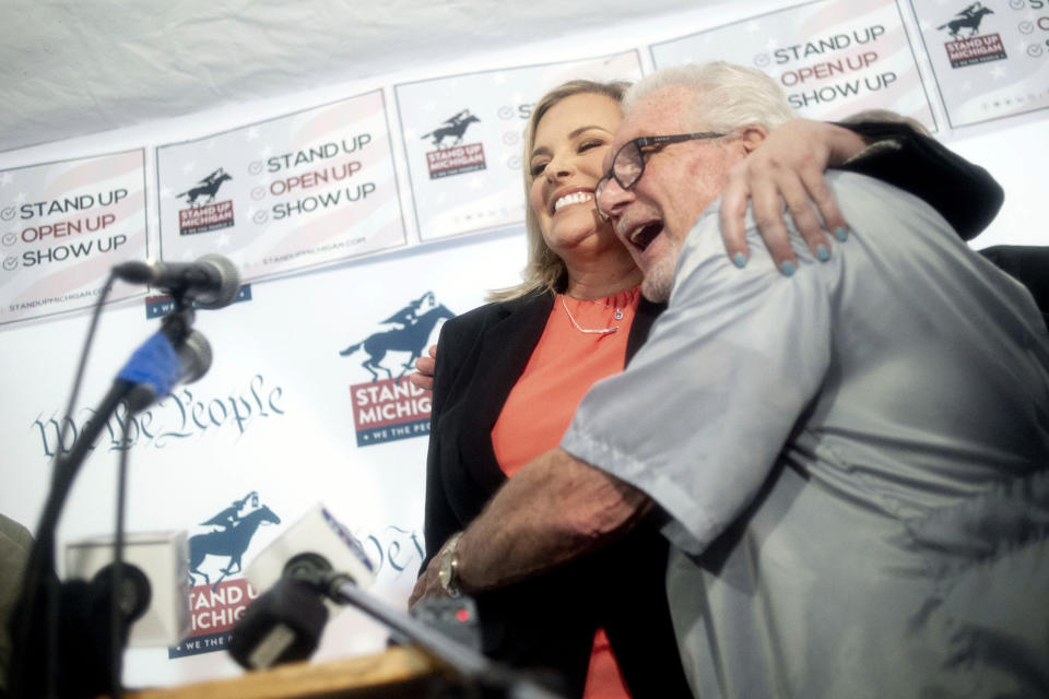 FILE - In this May 18, 2020, file photo, Texas hairstylist Shelley Luther hugs barber Karl Manke as she speaks during a news conference outside of Karl Manke's Barber and Beauty in Owosso, Mich. His license was suspended last week by Michigan regulators for cutting hair in his shop. (Jake May/The Flint Journal via AP)