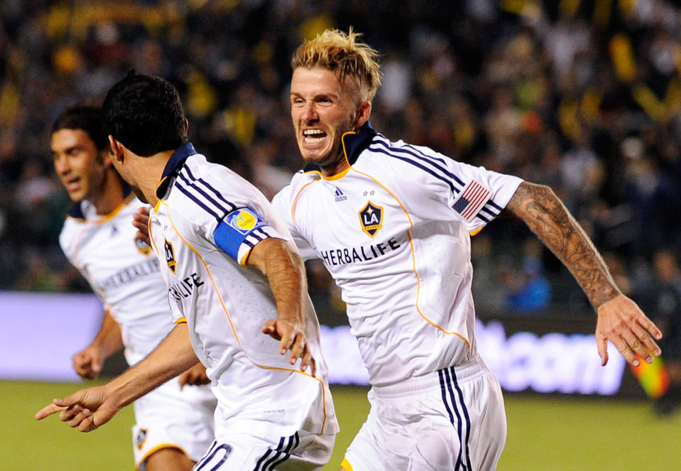 CARSON, CA - NOVEMBER 13: David Beckham #23 (R) of the Los Angeles Galaxy chases teammate Landon Donovan #10 to celebrate after Donovan's goal on a penalty kick against Houston Dynamo during the MLS Western Conference Championship soccer match at The Home Depot Center on November 13, 2009 in Carson, California. (Photo by Kevork Djansezian/Getty Images)