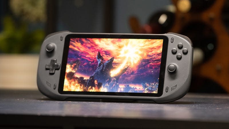 The Abxylute handheld with a game on screen featuring a fiery volcano, leaning against an unseen support while sitting on a table.