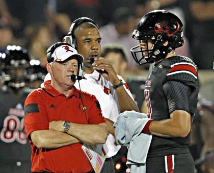 Bobby Petrino (L) talks with quarterback Will Gardner during a timeout. (AP)