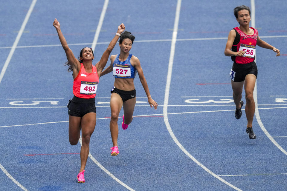 Singapore's Veronica Shanti Pereira, from left, crosses the finish line before Thailand's Supanich Poolkerd and Vietnam's Thinhi Yen Tran in the women's 100-meter final at the 32nd Southeast Asian Games in Phnom Penh, Cambodia, Friday, May 12, 2023. (AP Photo/Tatan Syuflana)