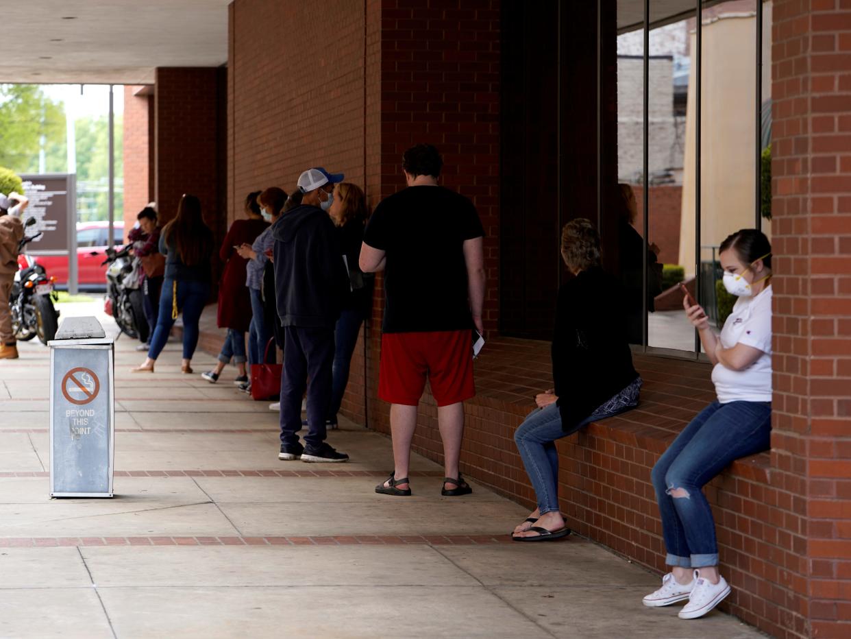 FILE PHOTO: People who lost their jobs wait in line to file for unemployment following an outbreak of the coronavirus disease (COVID-19), at an Arkansas Workforce Center in Fort Smith, Arkansas, U.S. April 6, 2020. REUTERS/Nick Oxford