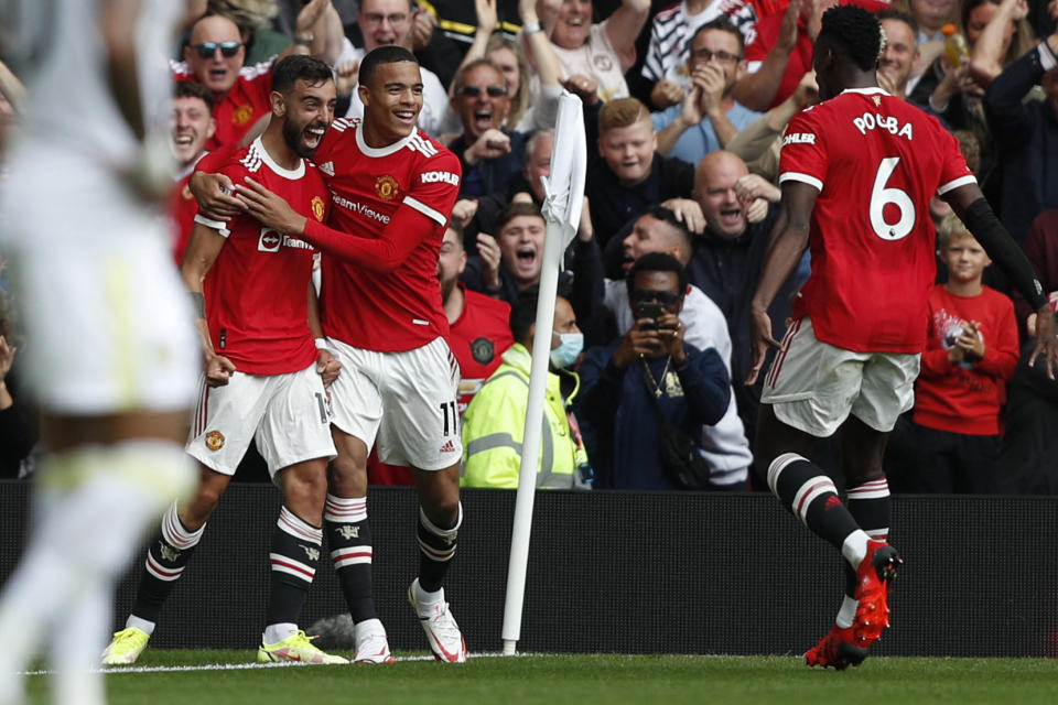 Manchester United's Portuguese midfielder Bruno Fernandes (left) celebrates scoring his team's first goal against Leeds with Mason Greenwood (centre) and Paul Pogba.