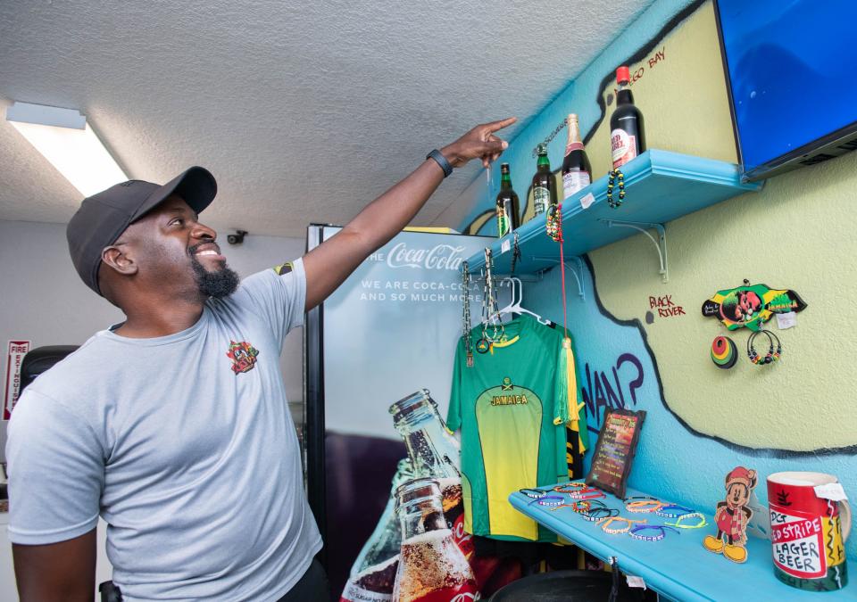 Owner Nash Smith points out his hometown of Montego Bay on a map of Jamaica on the wall at Gud Vybz Jamaican Grill at 4352 Avalon Boulevard in Milton on Tuesday, Sept. 13, 2022.