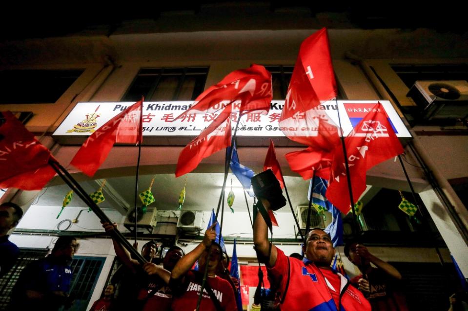 Supporters wave Pakatan Harapan and Barisan Nasional flags during the announcement of Kuala Kubu Baru by-election candidate at the DAP Operation Centre in Kuala Kubu Baru April 24, 2024. PH would retain the seat with an overall turnout of 58 per cent and if Chinese support reaches 90 per cent, Indian support 80 per cent and Malay support at just 20 per cent, Ong estimated. — Picture by Sayuti Zainudin