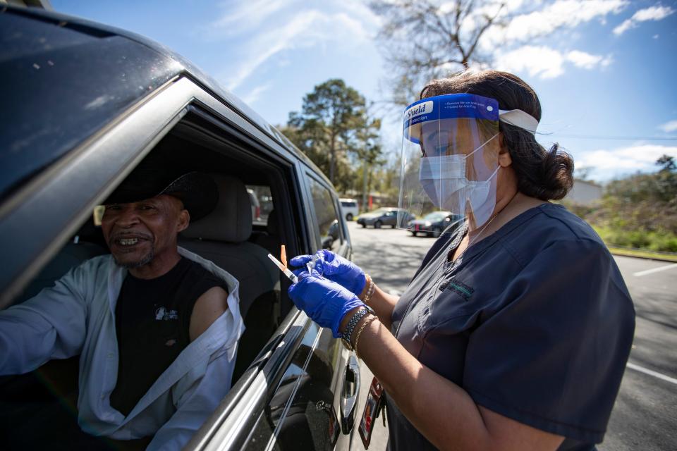 Dr. Temple Robinson, Bond Community Health Center’s CEO, gives a second dose of the COVID19 vaccine to Bernard DuPane on Wednesday, March 10, 2021.