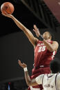 Alabama guard Nimari Burnett (25) scores a basket past Texas A&M guard Wade Taylor IV (4) during the first half of an NCAA college basketball game Saturday, March 4, 2023, in College Station, Texas. (AP Photo/Sam Craft)